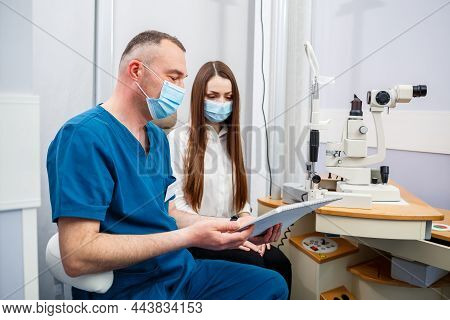 Ophthalmologist Consultation In A Modern New Hospital. A Modern Doctor Working With The Patient's He