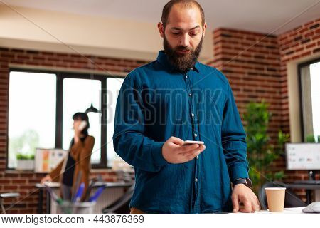 Businessman Holding Modern Smartphone Waiting For Imporant Call Looking At Watch Time While Working 