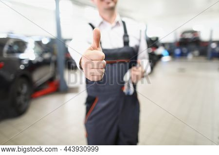 Close-up Of Male Worker In Uniform Showing Thumbs Up Posing In Garage. Fixed Car After Maintenance I