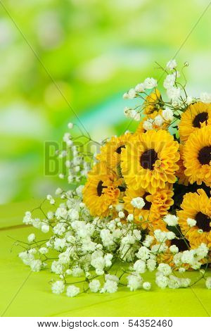 Beautiful flowers on table on bright background