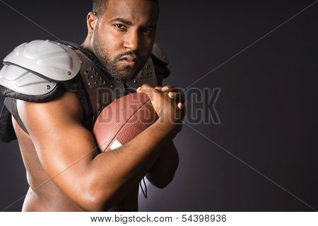 Angry African American Male Football Player Holds Ball Tight