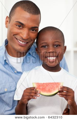 Retrato de um menino sorridente, comer frutas com o pai