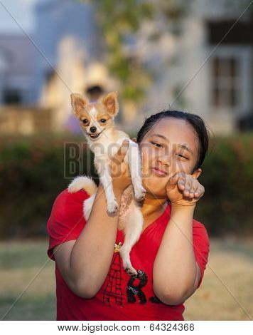 Girl And Pomeranian Dog Playing In Park