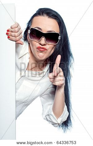 Girl Peeking Out From Behind A Poster.