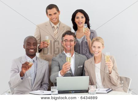 Equipo de negocios multiétnica celebrar un éxito con Champagne