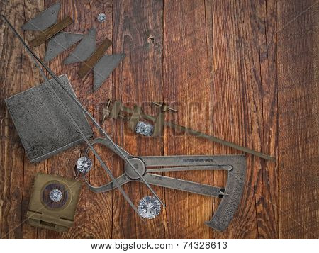 vintage jeweler tools and diamonds over wooden bench, space for text