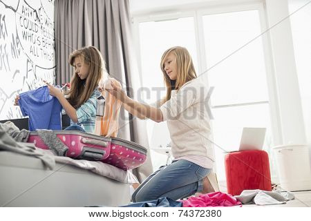 Sisters cleaning bedroom