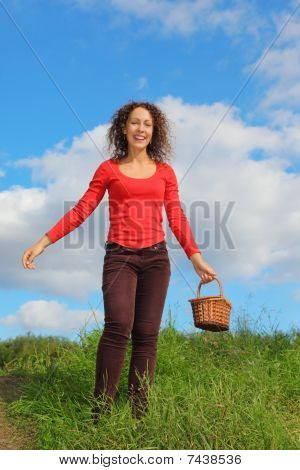 mosolygó nő visel pólót és farmert, pottle szabadban sétál