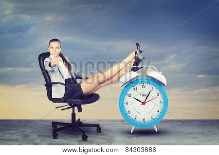 Woman in jacket and skirt sitting on chair. Background of road with clouds