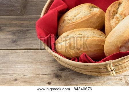 Bread Rolls In A Basket Whith Red Napkin On Old Wood