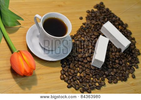 Coffee In A Cup And Coffee Beans With A Fresh Tulip And Marshmellow