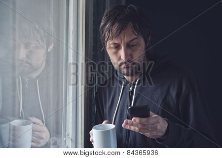 Drinking Coffee And Reading Sms On Mobile Phone In Morning