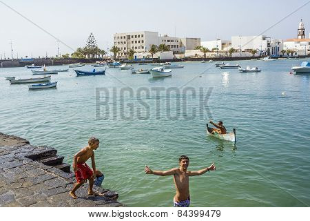 Boy Paddles With His Small Canoe