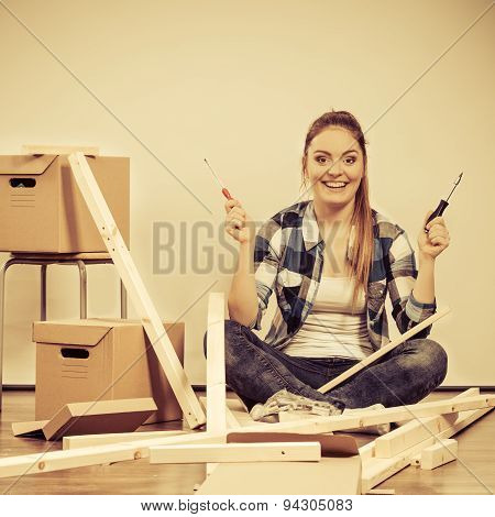 Woman Moving Into Apartment Assembly Furniture.