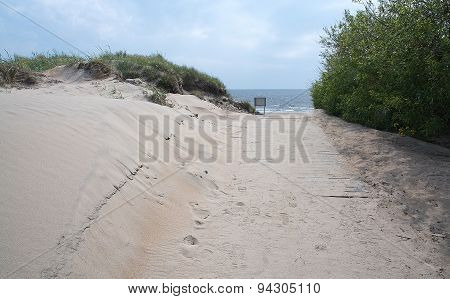 Pedestrian beach boardwalk with sand and sky