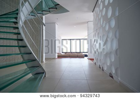 modern glass spiral staircase with metallic hand-rails.