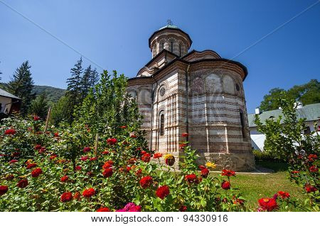 Cozia Monastery Church With Red Flowers On A Sunny Summer Day