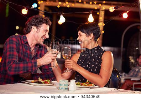 Couple eating dinner at rooftop restuarant