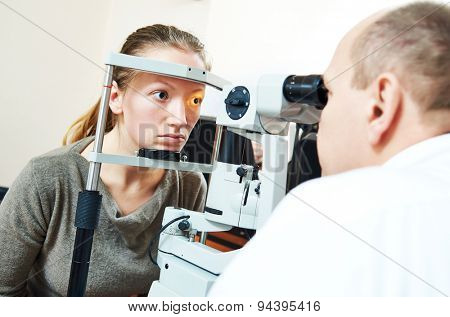 Adult optometry. male optometrist optician doctor examines eyesight of young woman patient in eye ophthalmological clinic 