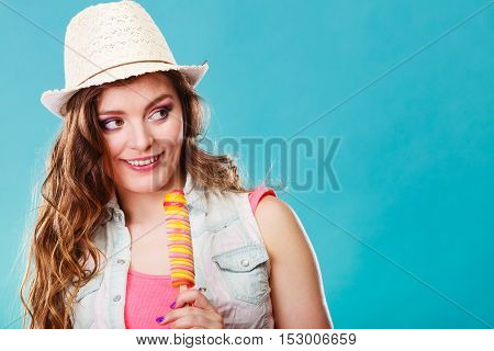 Summer vacation happiness concept. Smiling joyful and cheerful woman fashionable female model eating popsicle ice pop on blue background