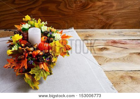 Thanksgiving centerpiece with artificial fall leaves. Thanksgiving background with fall decor. Fall background. Copy space.