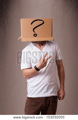 Young man standing and gesturing with a cardboard box on his head with question mark