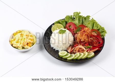 Home made,Jasmine rice with spicy fried chicken salad (Khao Yum Kai Zap in Thai) topped sliced cucumber,tomato,halved lemon and lettuce served with mixed vegetables salad.