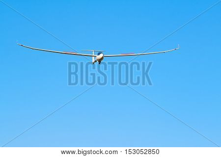 A sailplane in front of a blue sky glides through the air without its own motor drive.