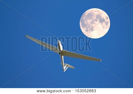 A sailplane in front of a blue sky glides through the air without its own motor drive.