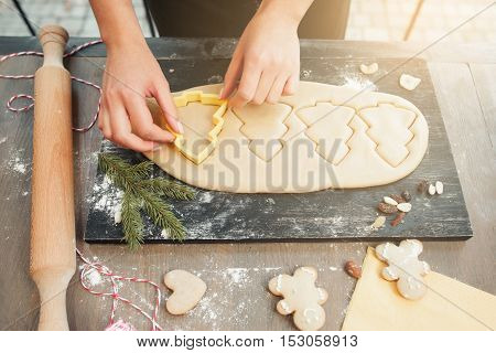Christmas tree gingerbread cookies making. Female hands forming traditional xmas treat at kitchen. Homemade bakery, xmas sweet, winter holidays concept