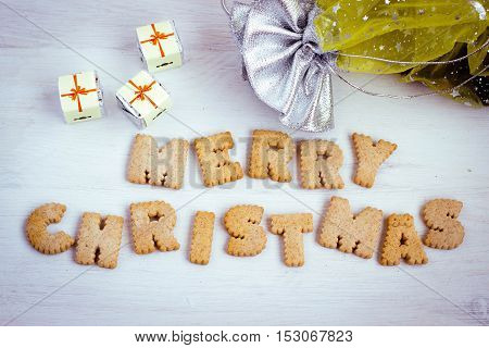 Chocolate gifts and biscuit-made lettering "Merry Christmas" on wooden table. Toned image. Happy New Year and Merry Christmas background. Merry Christmas greeting card. New Year wishes. New Year and Christmas background.