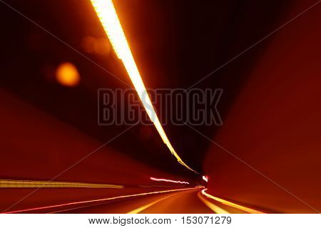 abstract blurred or defocused light motion on speed race in illuminated road tunnel yellow color as design flash background