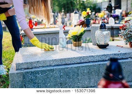 Woman Cleans A Grave With Sponge.