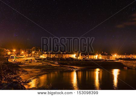 Craster Village at night, with stars above on the Northumberland Coast, with just a hint of the Aurora Borealis