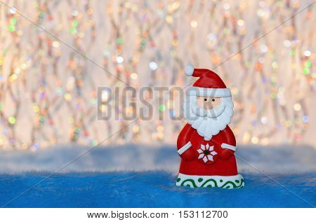 Figurine toy Santa Claus on colorful undulation bokeh background. Suitable for New year or Christmas background.