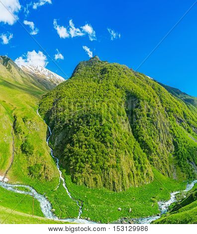 The waterfall from Chaukhi Mountain Range flows into the Jutistskali river in Juta gorge Kazbegi Georgia.