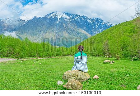 The best way to relax during the long mountain climb is to sit on some scenic forest glade Kazbegi National Park Georgia.