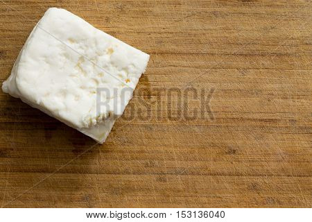 Cube Of White Cheese On Cutting Board