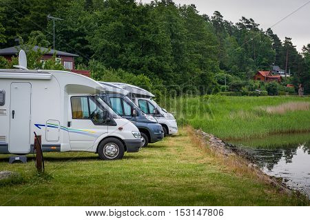 Auto campers parked at lake's shore. Lovoy island camping, Norway.
