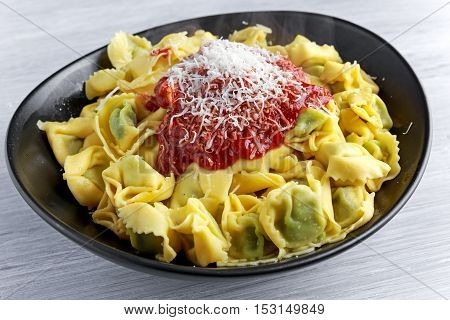 Traditional Italian homemade spinach and ricotta tortellini With marinara souce and parmesan.