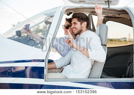 Happy smiling couple making selfie inside plane cabin after landing