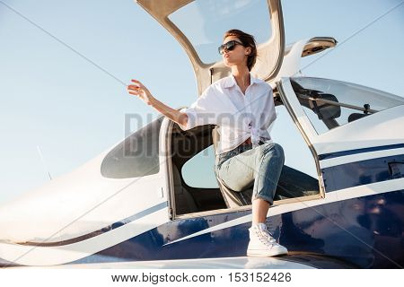 Young beautiful girl going out from the airplane after landing