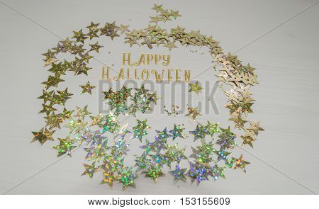 pumpkin from golden stars with happy Halloween wishes on white background