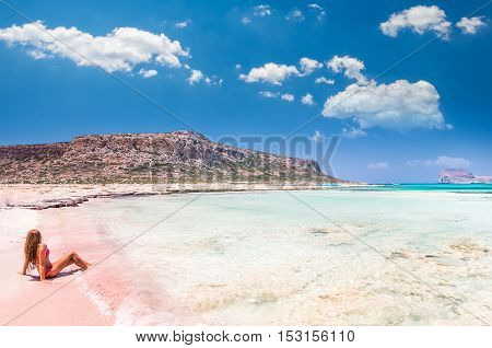 Balos lagoon on Crete island, Greece. A girl on a beach with pink sand.
