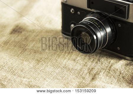 Outdated vintage silver retro camera in the corner of the image