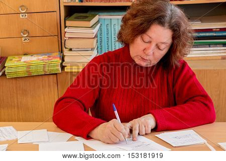 Woman writes on the form, documents and business papers