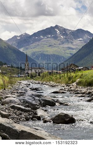 Spol River With Church Of Santa Maria In Livigno, Italy