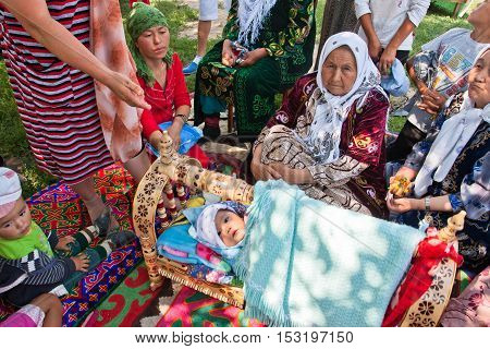 KEMIN, KYRGYZSTAN - AUGUST 2, 2013: Elderly village women tell the story of folk traditions of childbirth on August 2, 2013 in Kyrgyzstan. Central Asian Kyrgyzstan has population near 5.4 million