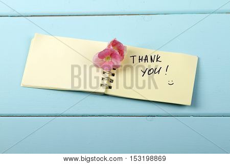 Thank You flower A spiral Notepad that has the words Thank You over a distressed wood turquoise background