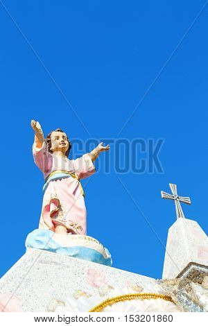 Vertical image in color of a tomb with jesus arms wide open
